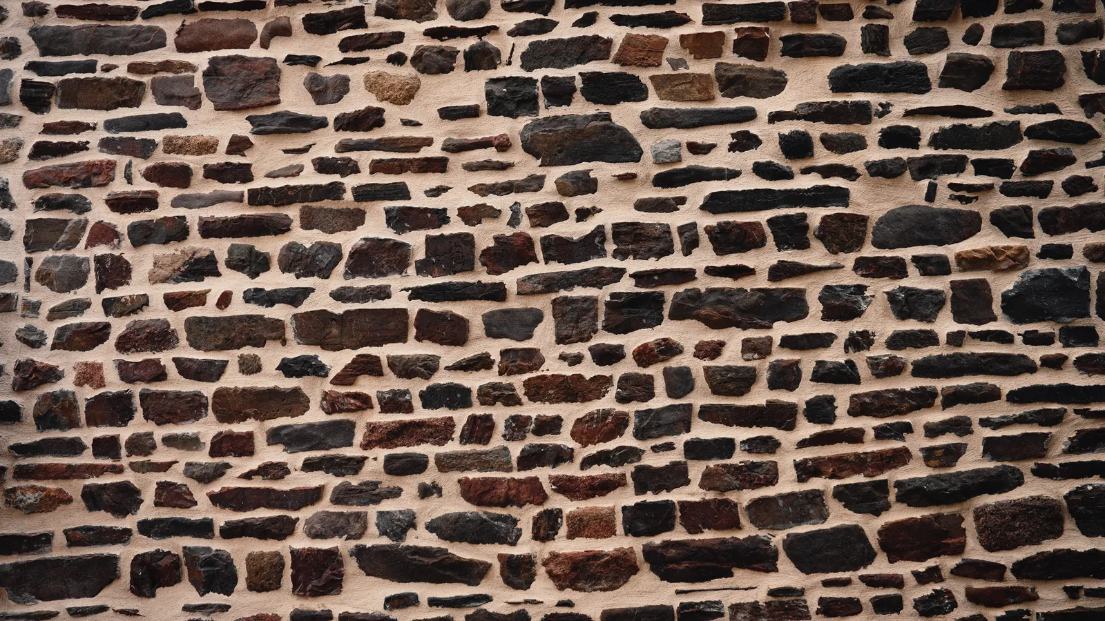 Mur en moellons de schiste et de grès aux joints beurrés de mortier clair.