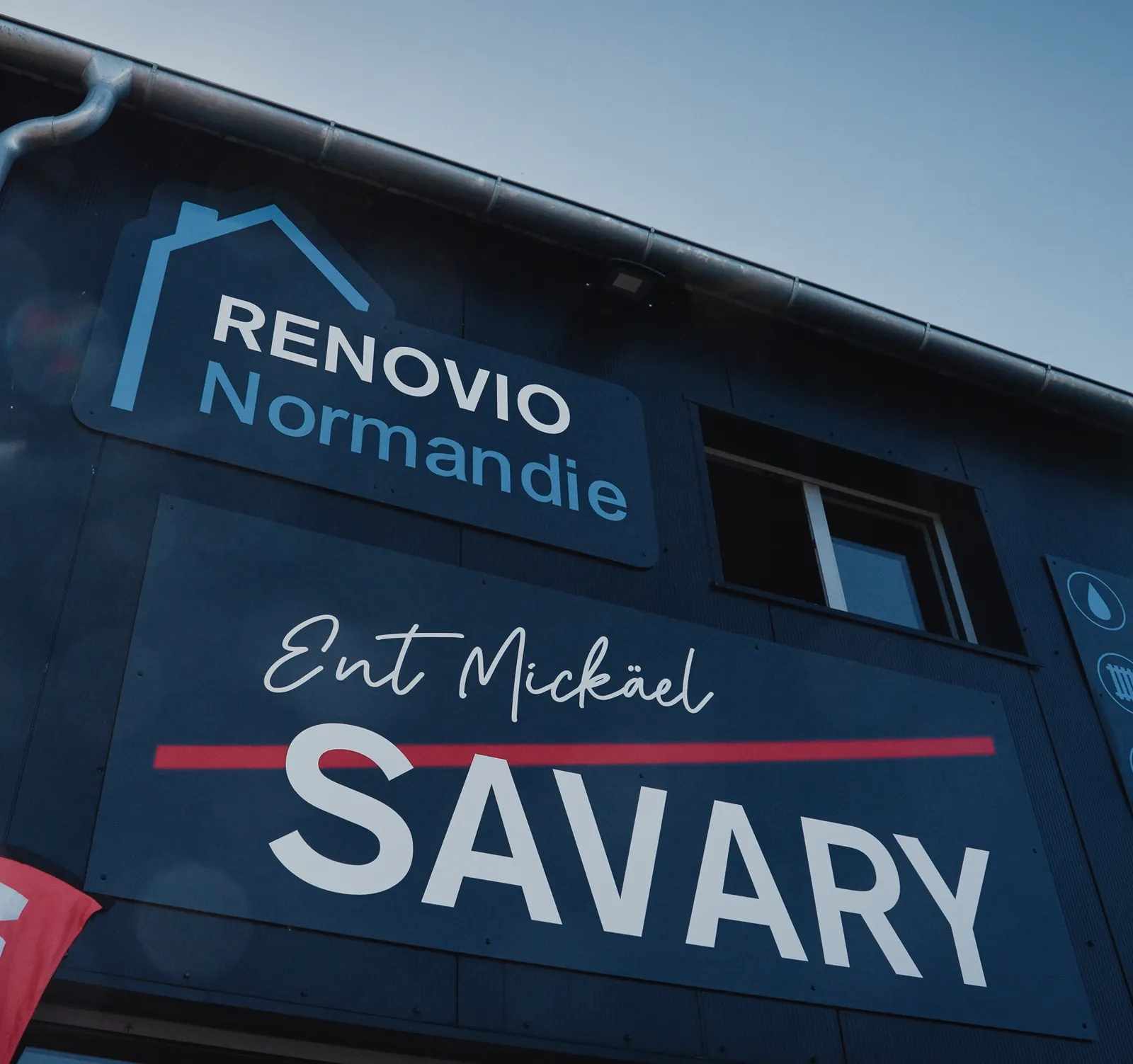 Façade en bardage noir du bureau, aux enseignes Renovio Normandie et SAVARY.