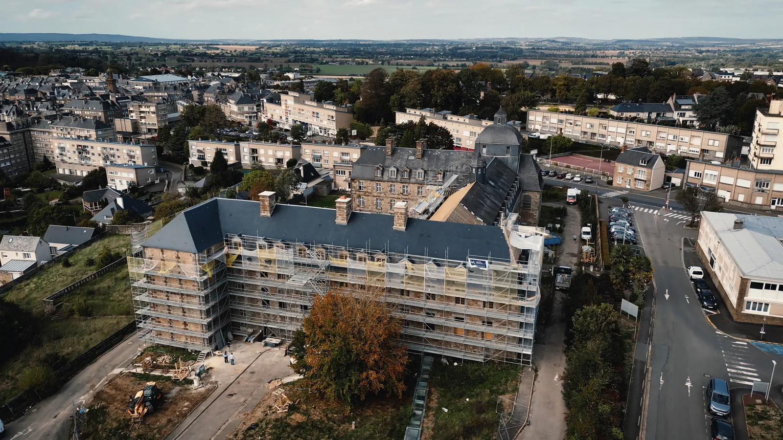 Vue du ciel d’un grand bâtiment en ville, entièrement sous échafaudage.