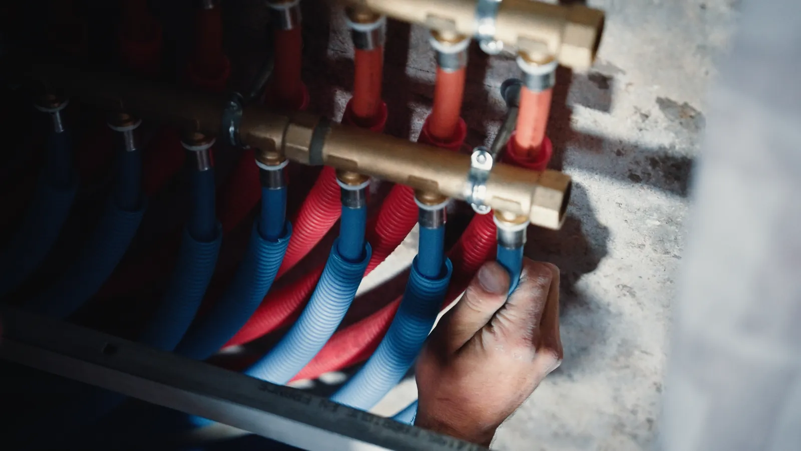 Collecteur en laiton et tubes rouges et bleus, en gros plan.